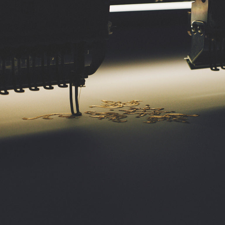 Close-up of a sewing machine needle and thread on a dark background
