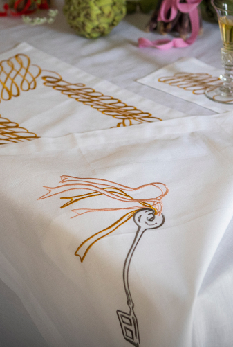 Folded embroidered table linen, napkins with custom bespoke designs