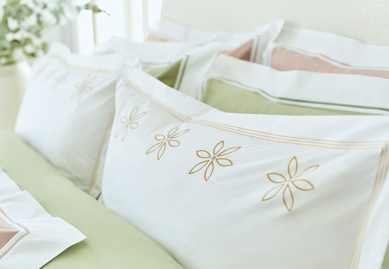 bespoke coloured linen bedding with daisy embroidery, signature cord details, and matching duvet cover, pillowcases, and fitted sheet